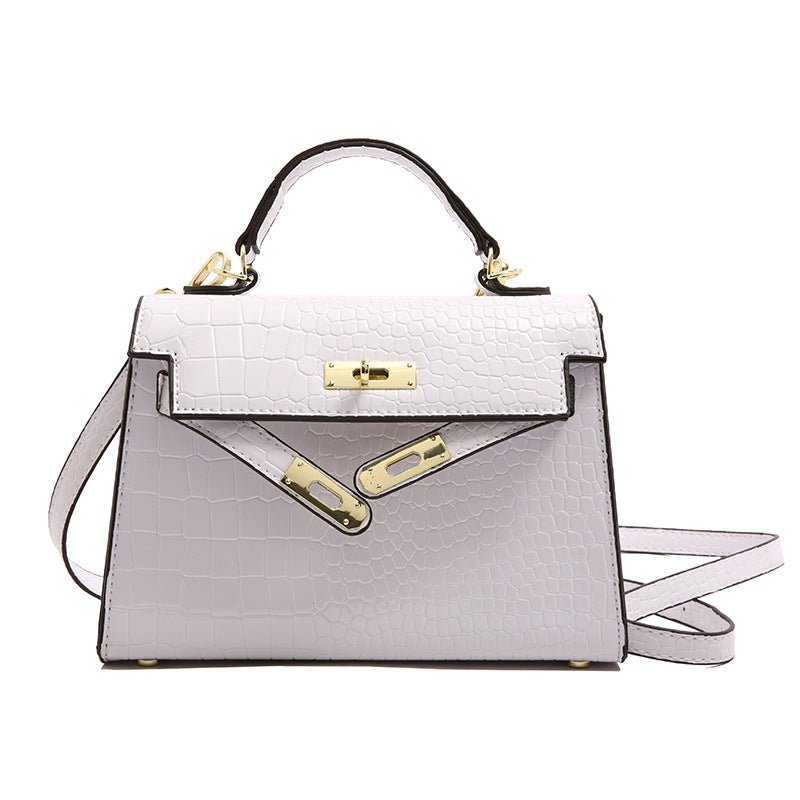 A woman carrying a small square bag with a lock