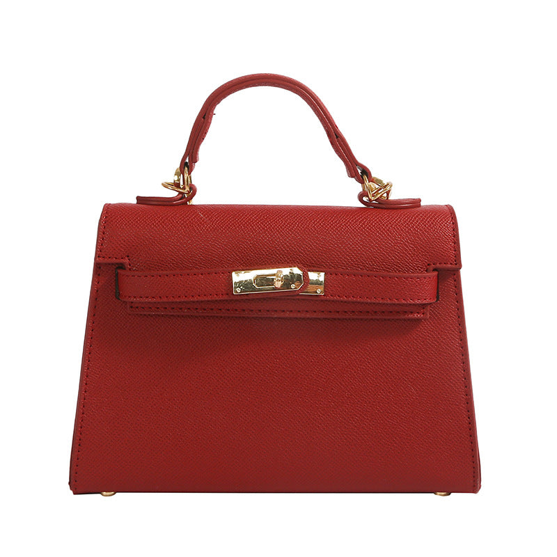 A woman carrying a small square bag with a lock